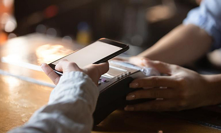 Close up view of a paying at a merchant by using mobile phone.