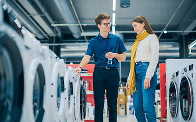 A male store employee discussing product display with a female customer.